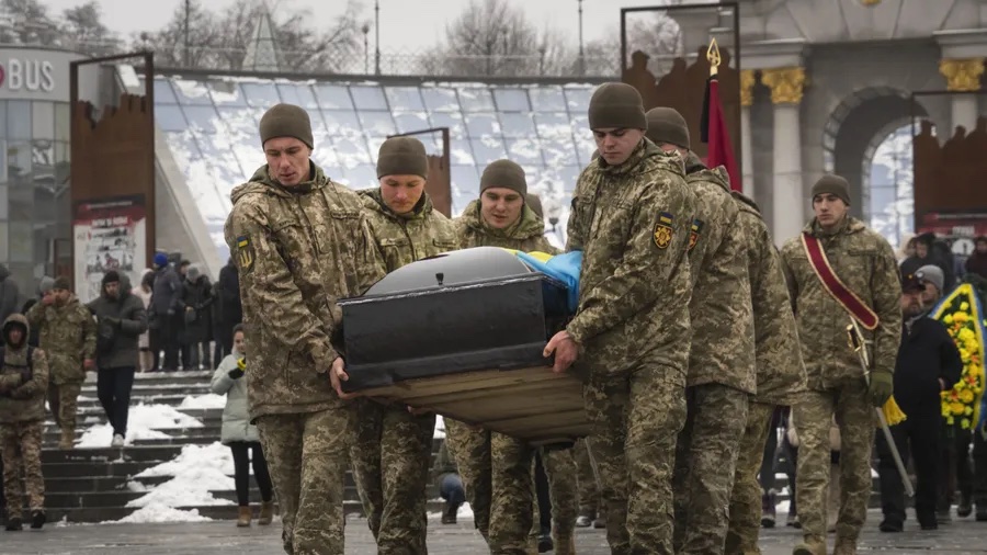 Ukrainian servicemen carry a coffin of their comrade Denis Galushko during a commemoration ceremony in Independence Square in Kyiv, Ukraine, Sunday, Jan. 12, 2023. The 38-year-old soldier died during a combat mission in the Donetsk region. (AP Photo/Efrem Lukatsky) [ EFREM LUKATSKY | AP ]